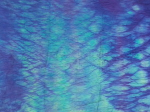 This piece of silk dupion was discharged, overdyed with Procion dyes, discharged, wrapped around a rope and then dyed in purple acid dye.  Love the shimmery, water look to this....