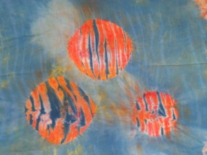 This piece started as orange hand-dyed rayon.  I then wrapped it on a pole (arashi shibori), discharged and over-dyed it.  Then I masked off the circles and dyed it again.  This has possibilities, too, don't you think?  