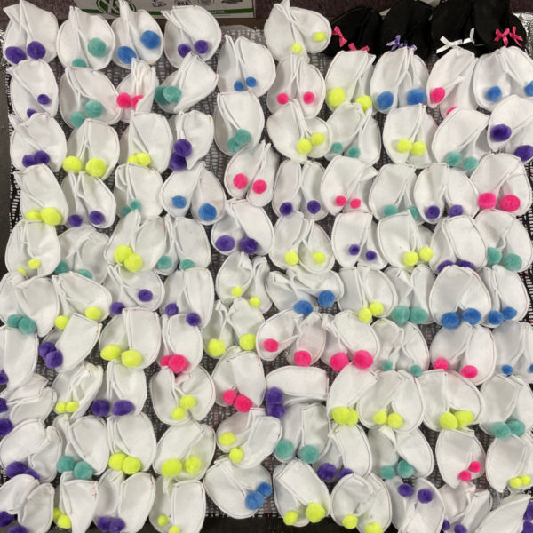 100 pairs of white booties embellised with pom poms