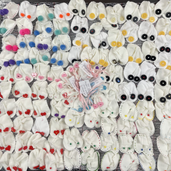 100 pairs of white baby booties 